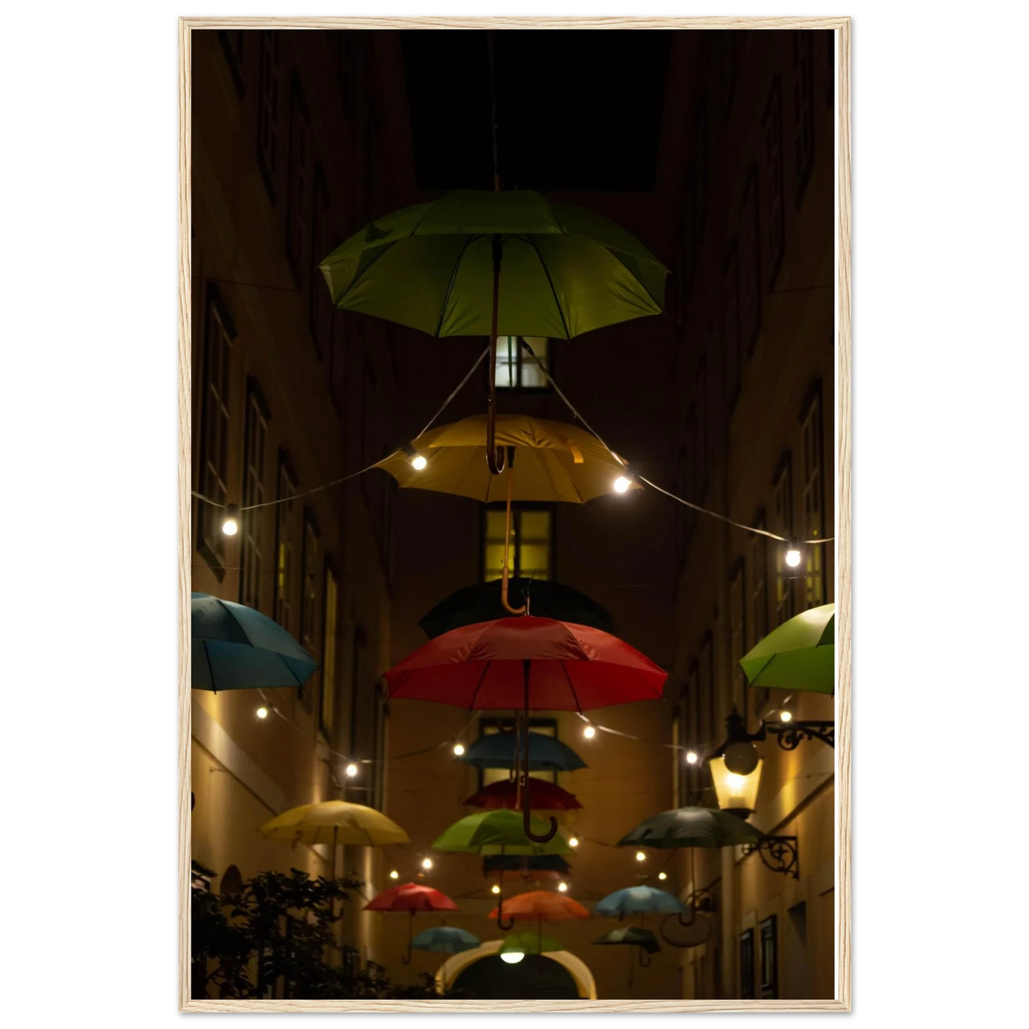 Nighttime street scene with colorful illuminated umbrellas hanging as decoration above a vibrant outdoor area on a wooden frame wall art