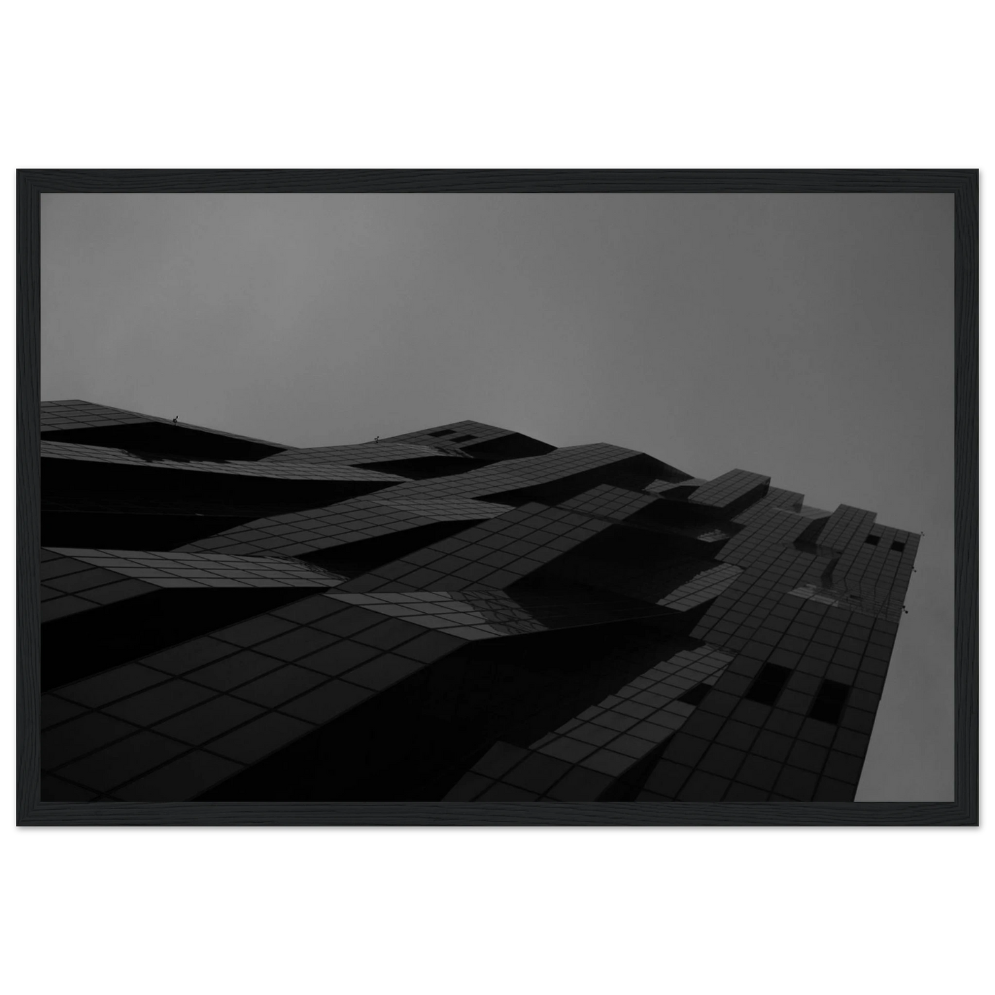 Black and white low angle view of a modern skyscraper with bold geometric lines and dark textured facade on wooden framed wall art