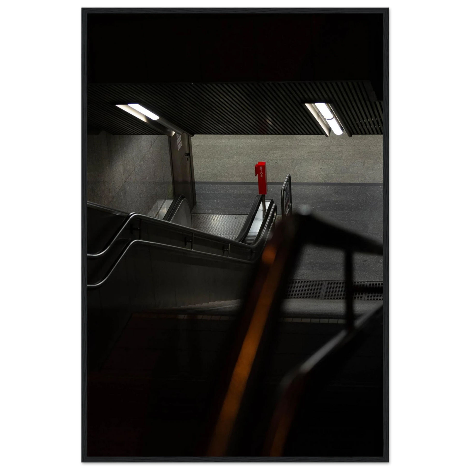 Nighttime view of a metro station entrance with illuminated signs and dark urban surroundings on wooden framed wall art