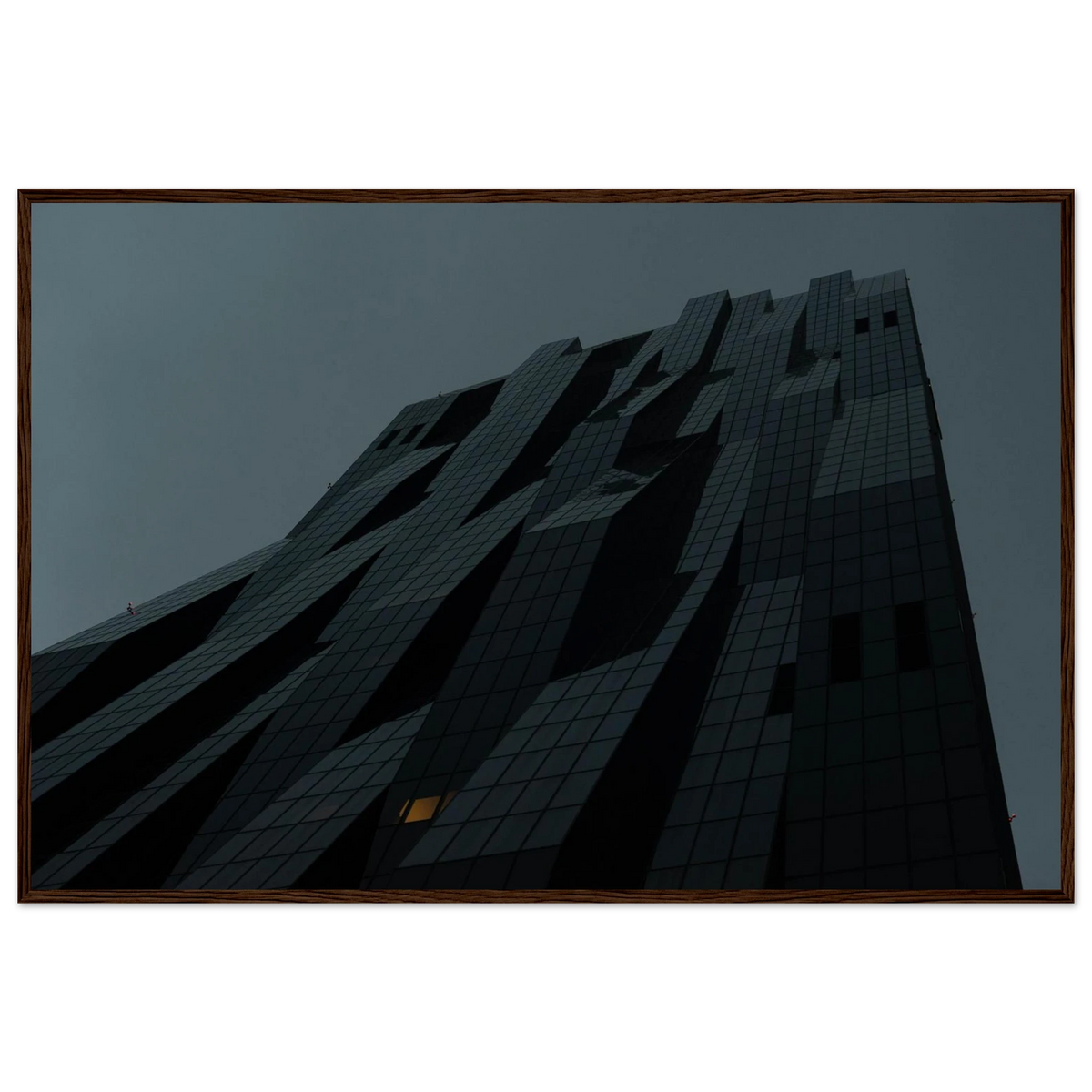 Bluish low angle view of a modern skyscraper with bold geometric lines and dark textured facade on Wooden framed wall art
