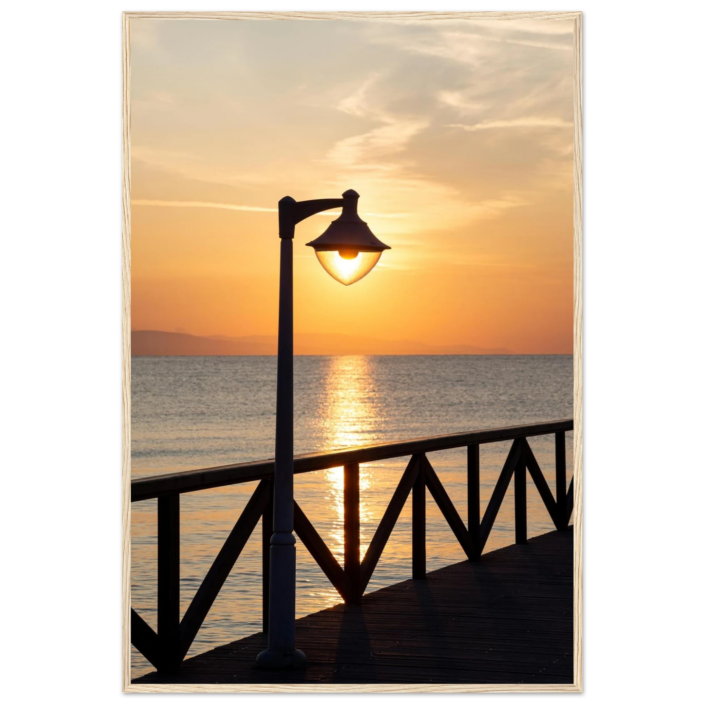 Wooden framed wall art of a sunset over the sea with a street lamp on the pier