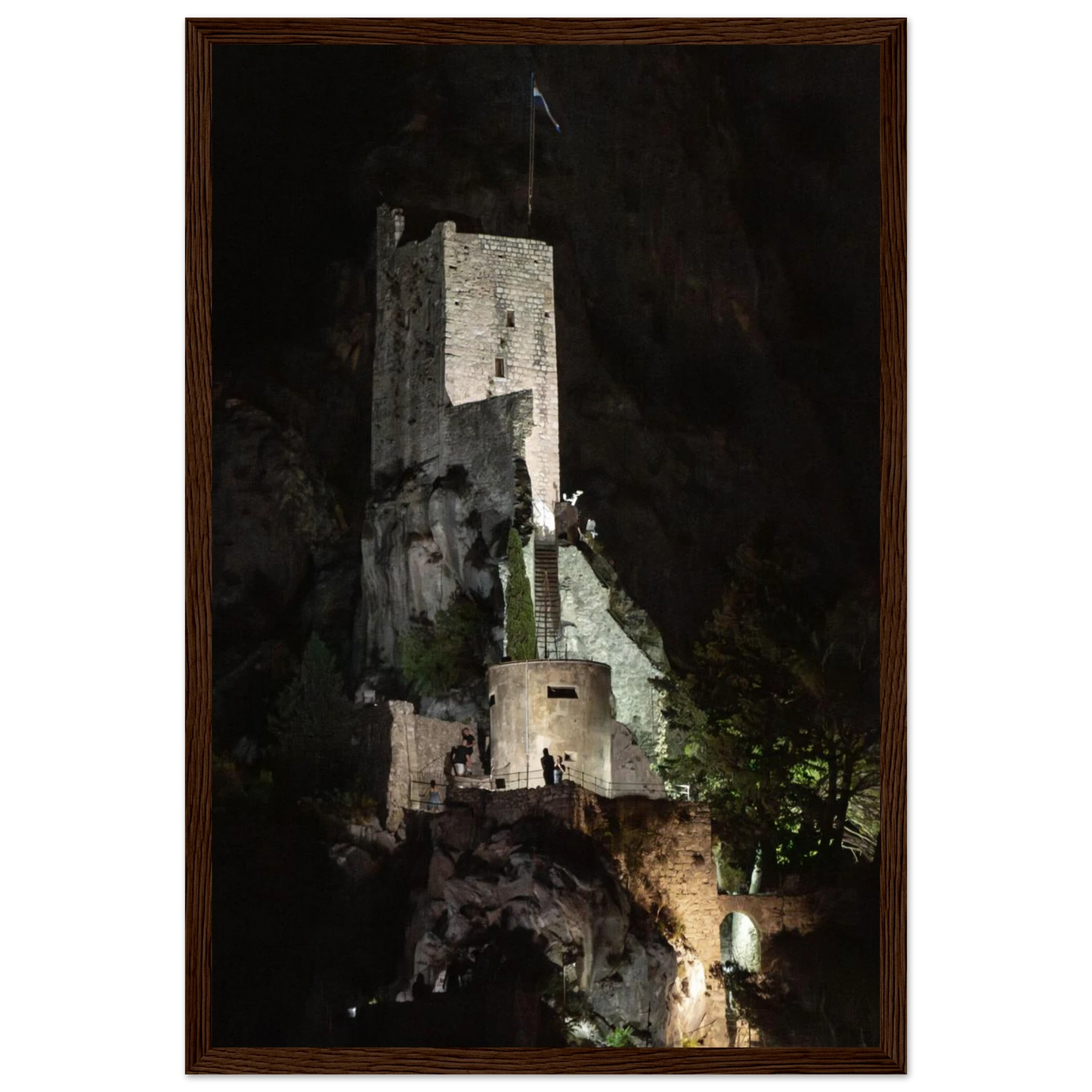 Wooden framed wall art of an ancient stone bastion decorated with green climbing plants against a dark background in Shadow Keep