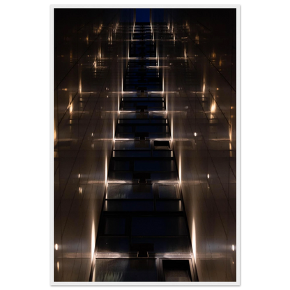 Low angle view looking up a narrow corridor-like passage between two skyscraper walls lined with rows of windows stretching toward the sky on wooden framed wall art