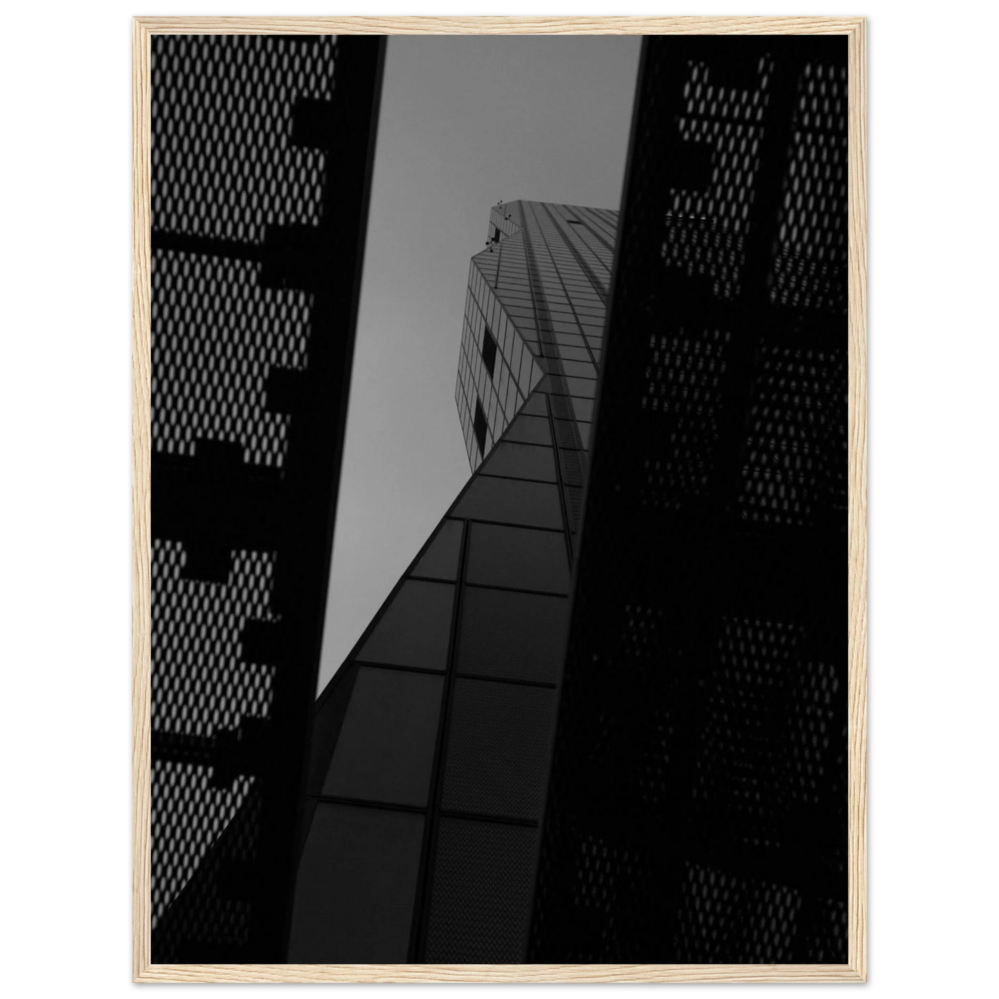 Black and white Low angle view looking up at a tall glass skyscraper framed between two metal structural elements on Wooden frame wall art
