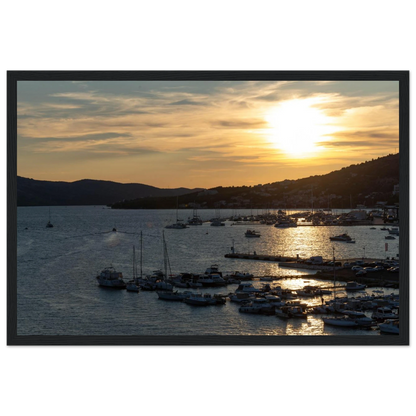 Wooden framed wall art of small boats anchored in a seaside port during Sunset at the harbor