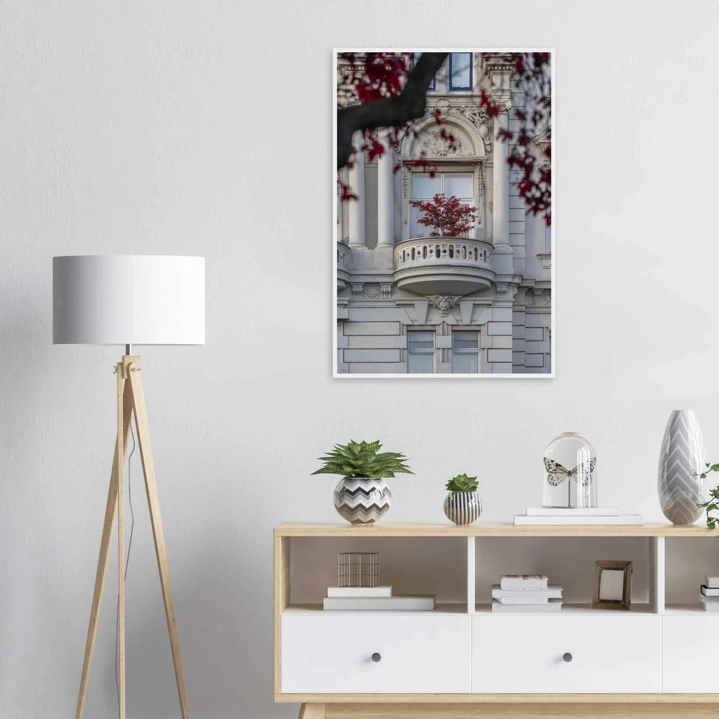 Red leaved tree in autumn colors in front of a historic stone building facade on wooden framed wall art on the wall in the Livingroom