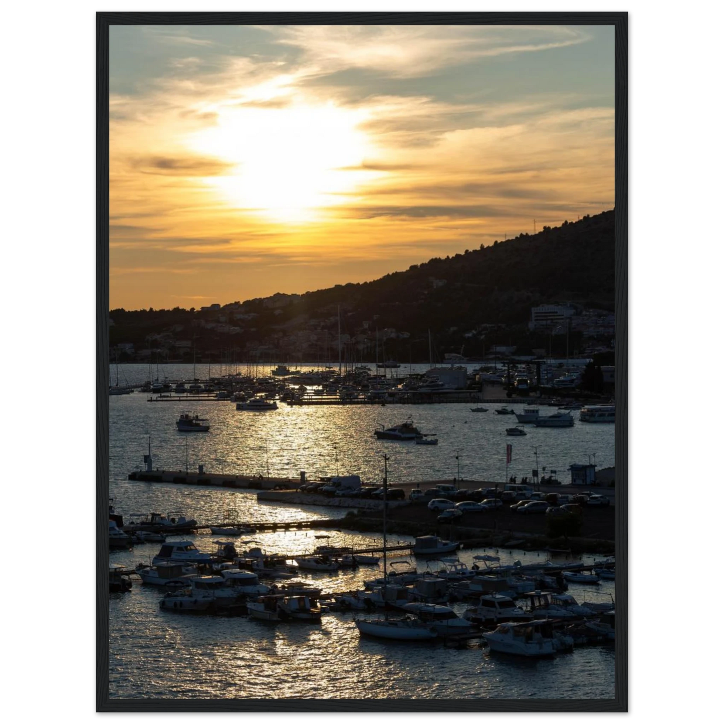 Wooden framed wall art of small boats anchored in a seaside port during Sunset at the harbor