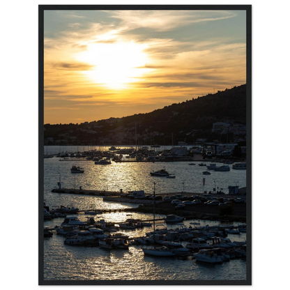Wooden framed wall art of small boats anchored in a seaside port during Sunset at the harbor