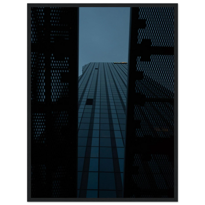 Low angle view looking up at a tall glass skyscraper framed between two metal structural elements on wooden framed wall art