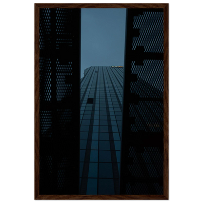 Low angle view looking up at a tall glass skyscraper framed between two metal structural elements on wooden framed wall art