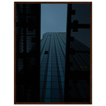 Low angle view looking up at a tall glass skyscraper framed between two metal structural elements on wooden framed wall art