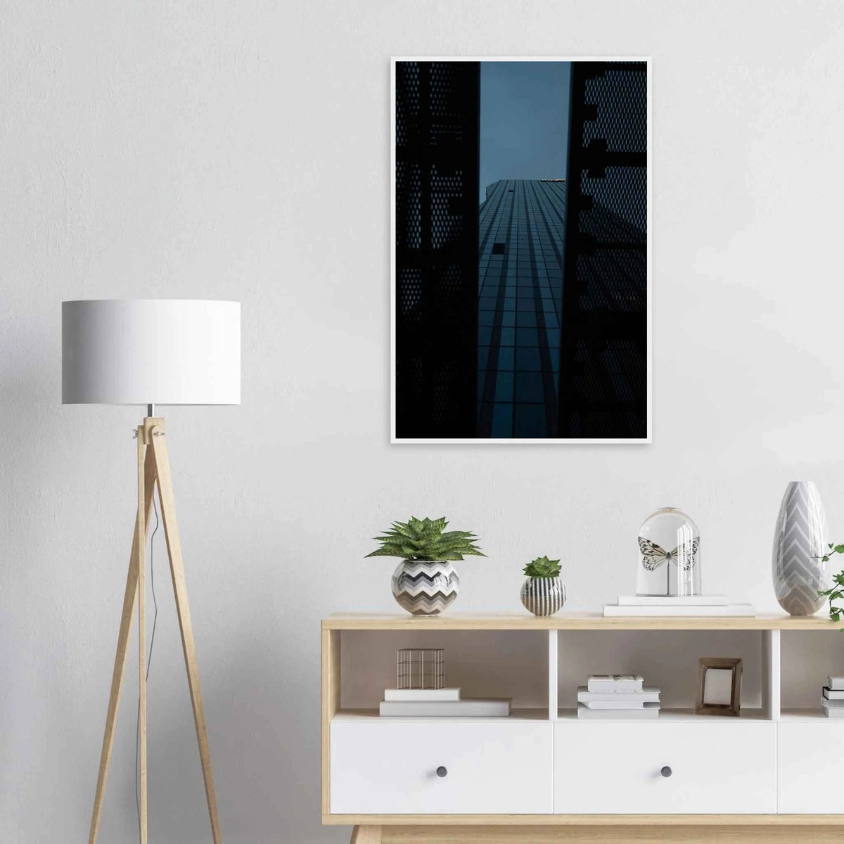 Low angle view looking up at a tall glass skyscraper framed between two metal structural elements on wooden framed wall art on the wall in the Livingroom