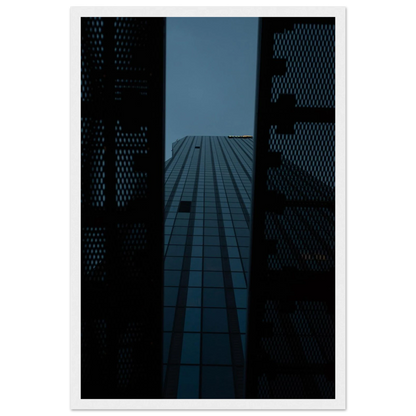 Low angle view looking up at a tall glass skyscraper framed between two metal structural elements on wooden framed wall art