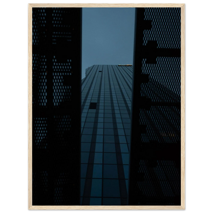 Low angle view looking up at a tall glass skyscraper framed between two metal structural elements on wooden framed wall art