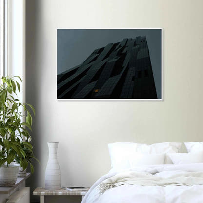 Bluish low angle view of a modern skyscraper with bold geometric lines and dark textured facade on Wooden framed wall art on the wall in the Bedroom