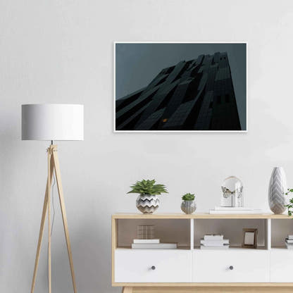Bluish low angle view of a modern skyscraper with bold geometric lines and dark textured facade on Wooden framed wall art on the wall in the Livingroom