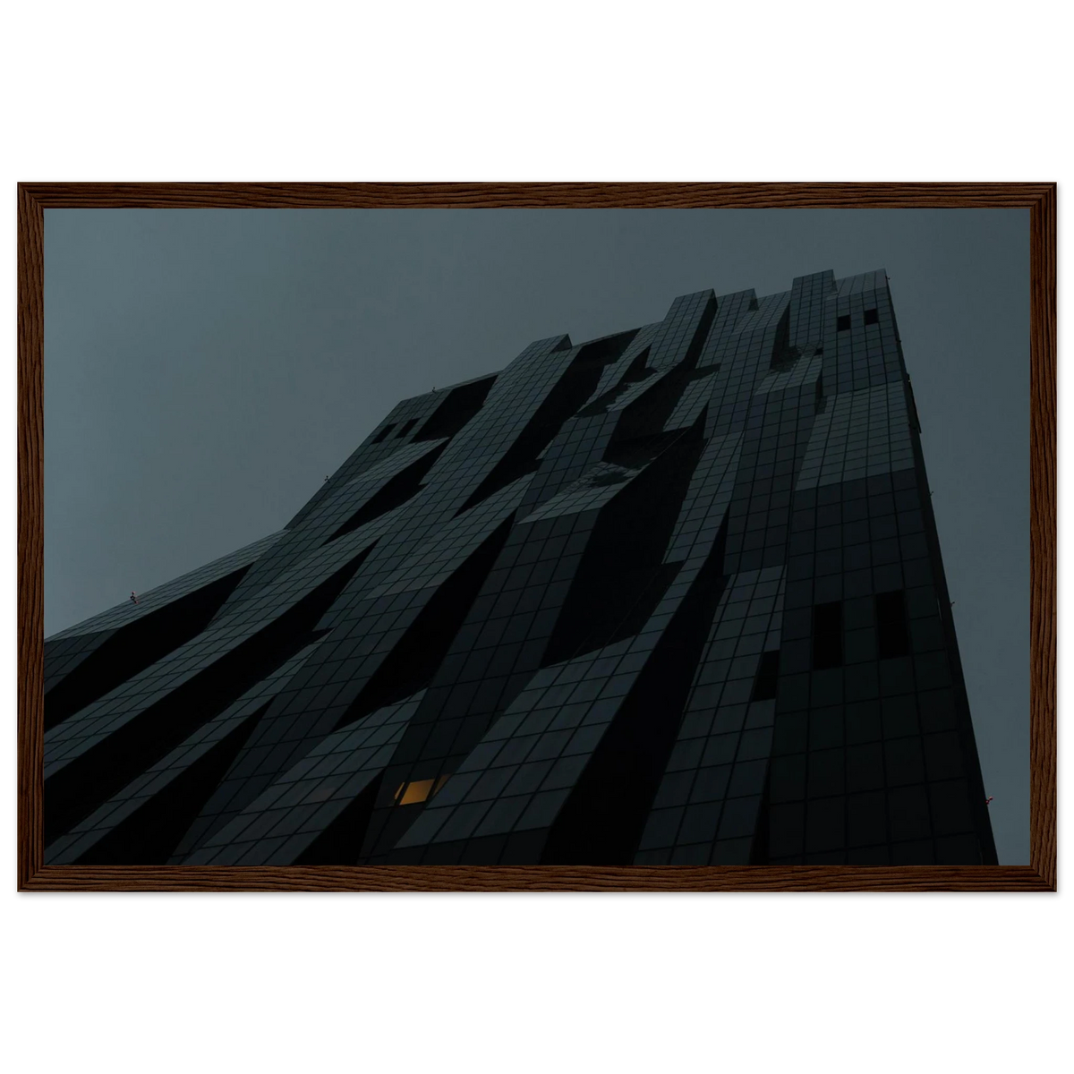 Bluish low angle view of a modern skyscraper with bold geometric lines and dark textured facade on Wooden framed wall art