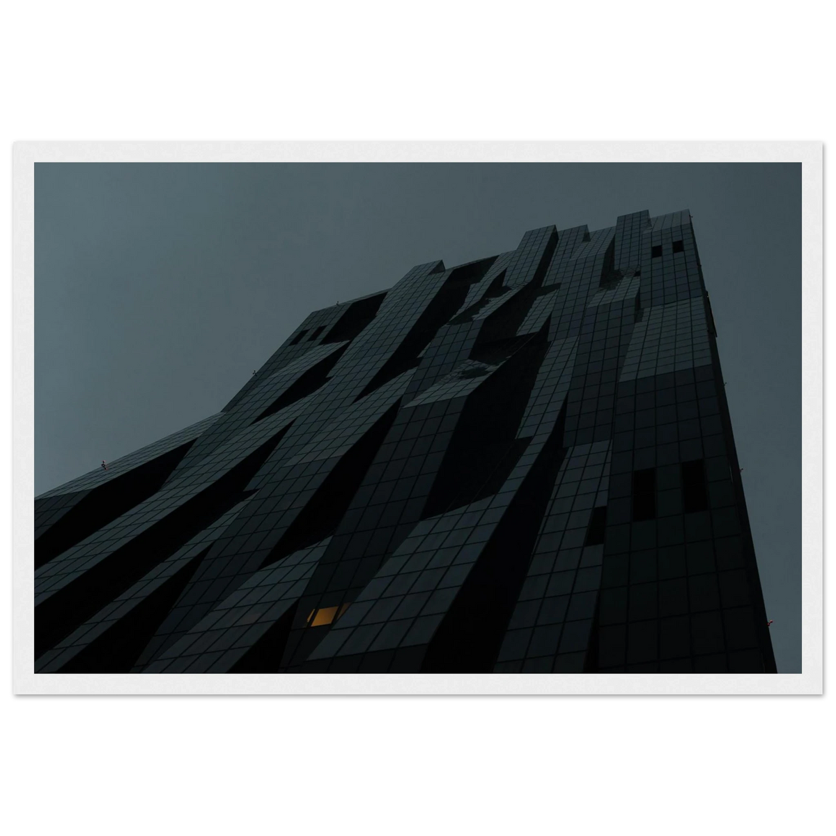 Bluish low angle view of a modern skyscraper with bold geometric lines and dark textured facade on Wooden framed wall art