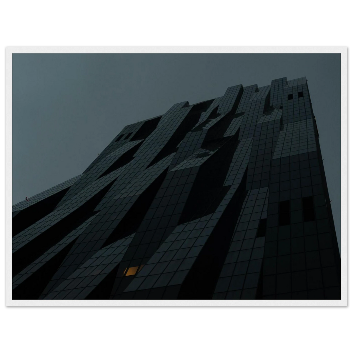 Bluish low angle view of a modern skyscraper with bold geometric lines and dark textured facade on Wooden framed wall art
