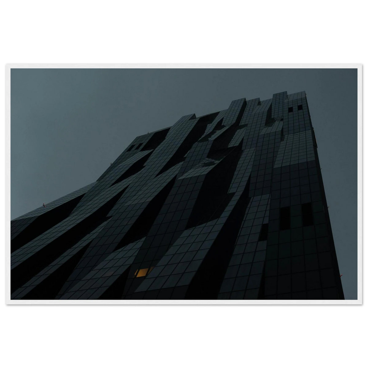 Bluish low angle view of a modern skyscraper with bold geometric lines and dark textured facade on Wooden framed wall art