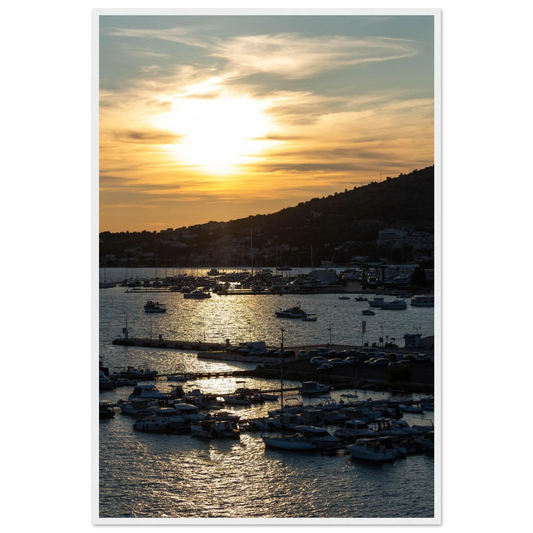 Wooden framed wall art of small boats anchored in a seaside port during Sunset at the harbor